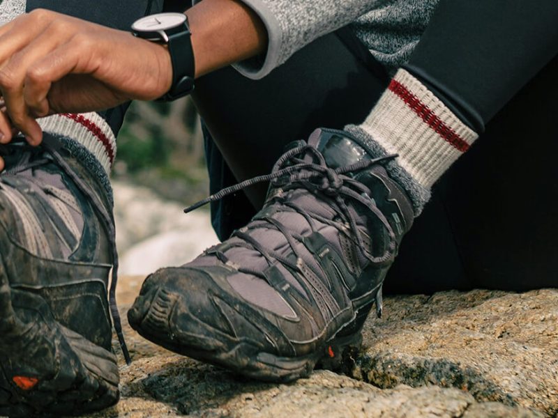 a walker tying her shoes on a hike